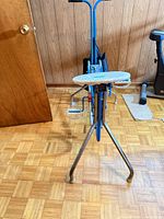 Front view showing white seat, blue frame, chrome legs and pedals