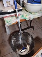 Top view showing hammered galvanized tub interior and reacher grabber tool placed inside