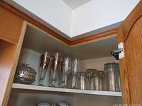 Cabinet shelf showing candy dish, champagne flutes, scalloped glasses, teacups