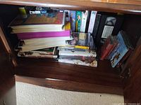Cabinet interior showing mixed VHS, DVD, CD stacks