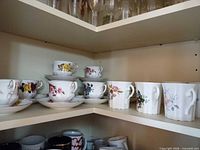 Teacups, saucers, and mugs staged on shelf