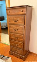 Full view of tall cherry veneer chest showing six drawers and hardware