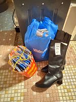 Boots standing beside bags filled with packaged hosiery