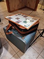 Stack showing Pinnacle frame atop black carry case and blue suitcase