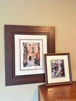 Both framed prints standing on dresser