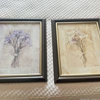 Both framed floral prints side by side on surface