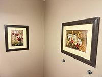 Two framed floral prints hanging on wall for scale