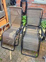 Pair of matching reclining sling-back chairs side by side