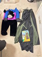 Entire lot showing gorilla rider costume, Wicked Witch gown, cape and product card