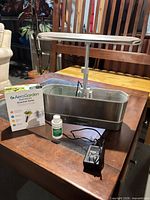 Full view of AeroGarden unit with LED arm, seed pod kit box, nutrient bottle, power adapter