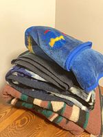 Stack of five blankets showing colors and textures