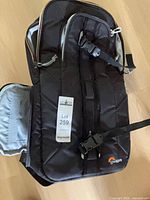 Front and top view of black Lowepro camera bag showing exterior straps and zipper