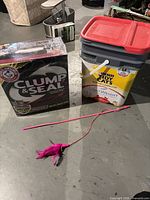 Group shot showing Arm & Hammer litter box, Purina litter pail and pink feather toy