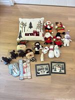 All items laid out: pillow, plush figures, ornaments, plaques, stocking holders, cross-stitch pictures