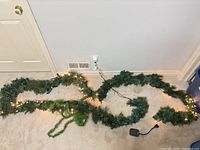 Garland length on floor showing lit and unlit sections, power cord visible