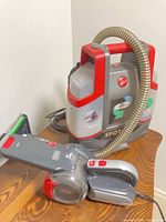 Hoover Spotless cleaner and Black+Decker Pivot vacuum on table
