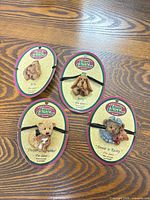 Four Cottage Collectibles pins on cards displayed on table