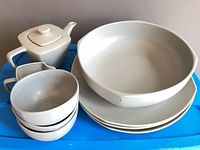 Entire group of dinnerware pieces on blue surface