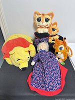 Group shot of all items: Pooh pillow, two Puss in Boots plushes, Bambi purse, 3-in-1 doll