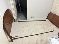 Overall view of dismantled bed frame showing headboard, footboard, side rails