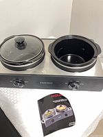 Front view of Paderno double slow cooker showing one lid present and stainless base with controls