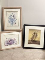 Group shot of three framed prints leaning against wall