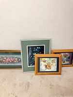 Four framed prints leaning against wall