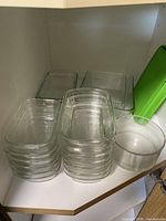 Stacked rectangular glass casserole dishes, mixing bowl, green lid