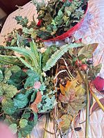Overview of red bowl and assortment of artificial stems spread on surface