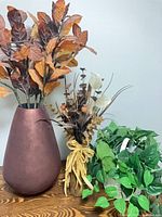 Group view: ceramic vase with autumn leaves, brown floral bundle, green pothos in white basket
