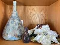 All three items on shelf: ceramic vase, glass bud vase, floral centerpiece with candle holder