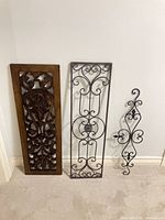 Three wall art pieces leaning against wall