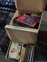 Two cardboard boxes labelled Language Arts and Math filled with assorted books and workbooks