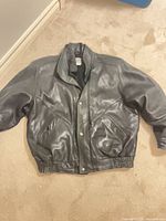 Full view of leather jacket laid flat