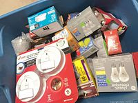 Overview of tote showing assorted bulb boxes and Kidde smoke alarms