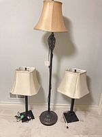 Full view of floor lamp centered between two table lamps