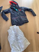 Overall view of both vest and jacket laid flat on floor