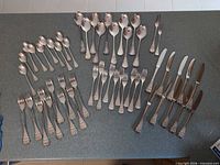 Full layout of all flatware pieces grouped by type on countertop