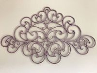 Front view of grey metal scroll wall art plaque