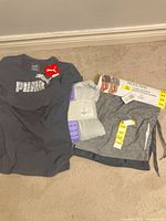 All three packaged/new clothing items laid out