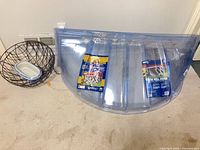 Clear plastic window well cover with packaging, two wire baskets, ceramic planter