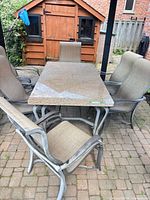 Full view of marble table with six sling-back chairs