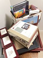 Assorted albums and frames stacked, showing quantities and variety