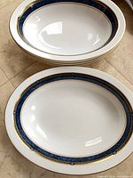 Stack of open vegetable bowls with visible blue and gold rim