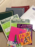 Group shot of scrapbooks, refill pages, page protectors, card stock, scissors and stencils