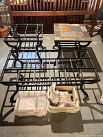 All three metal table frames and box of slate tiles visible
