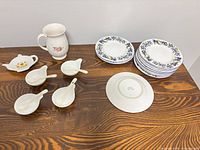 Group shot of all items: plates stack, creamer, bowls, spoons, spoon rest