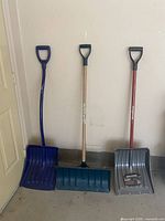 Three shovels standing against wall