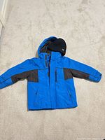 Front view of blue and brown Sportek kids jacket with black toque