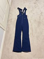 Full view of navy snow bib pants laid flat